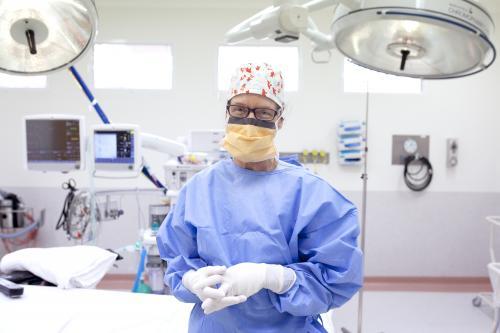 Female nurse dressed in protective clothing ready to perform surgery - Australian Stock Image