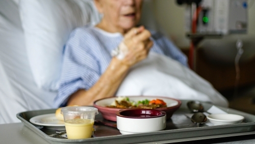 Female patient eating hospital food - Australian Stock Image