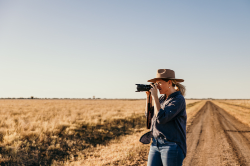 Female taking photo outdoors on farm - Australian Stock Image