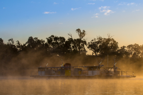 Ferry on river at sunrise - Australian Stock Image