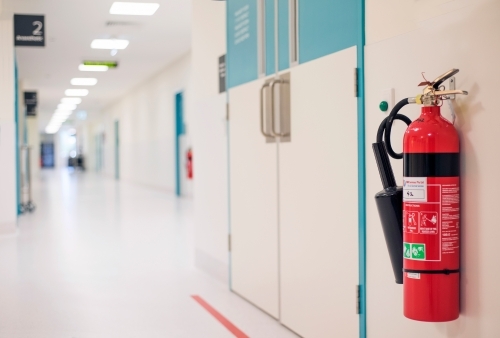 Fire extinguisher in a theatre hospital corridor. - Australian Stock Image