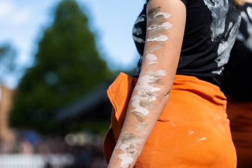 First nations dancer with traditional aboriginal paint on arm at ANZAC day ceremony - Australian Stock Image