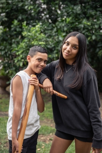 First Nations teenagers holding Indigenous instruments - Australian Stock Image