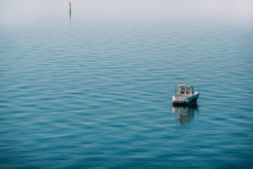 Fishing boat on the calm bay - Australian Stock Image