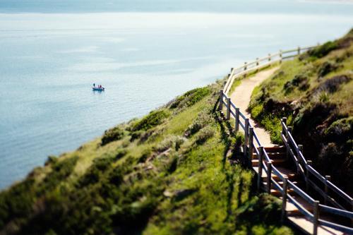 Fishing boat on the ocean with a coastal walkway - Australian Stock Image