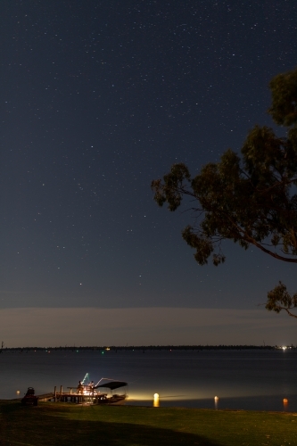 Fishing rod lights on lake jetty at night - Australian Stock Image