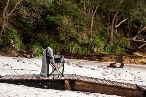 Fishing supplies on a fold-out chair on the beach - Australian Stock Image