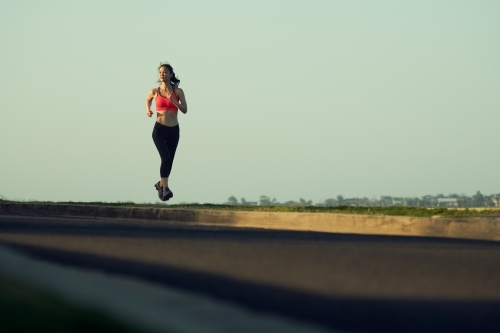 Fit Asian woman running for morning exercise - Australian Stock Image