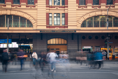 Flinders Street Station with pedestrians crossing the road - Australian Stock Image
