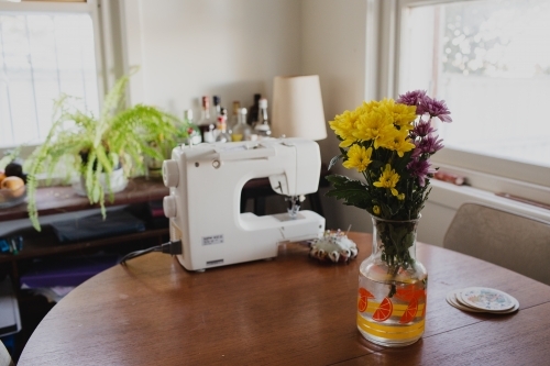 Flowers and sewing machine on table - Australian Stock Image