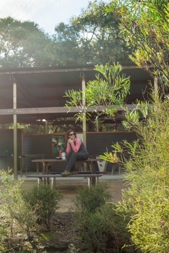focus on bush with Woman hiking Kangaroo Island Wilderness Trail resting at table - Australian Stock Image