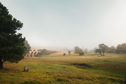Foggy morning in the valley with historic bridge - Australian Stock Image