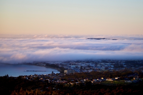 fogs layer sitting low over buildings in an urban area - Australian Stock Image