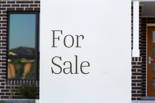 For sale sign outside of new brick house on real estate market - Australian Stock Image