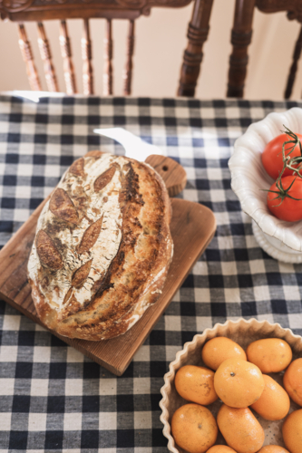 fresh sourdough on gingham tablecloth - Australian Stock Image