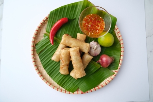 Freshly cooked Filipino food called Lumpiang Shanghai or fried pork spring rolls. - Australian Stock Image