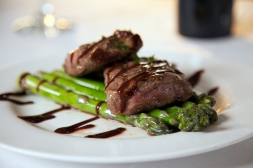 Freshly cooked steak on a plate with asparagus - Australian Stock Image