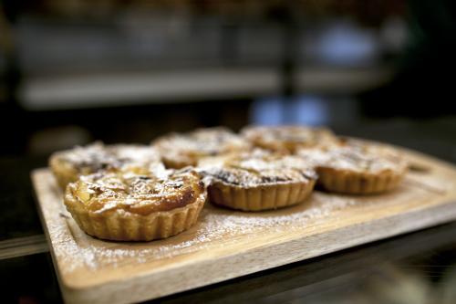 Freshly made tarts on display at bakery cafe - Australian Stock Image