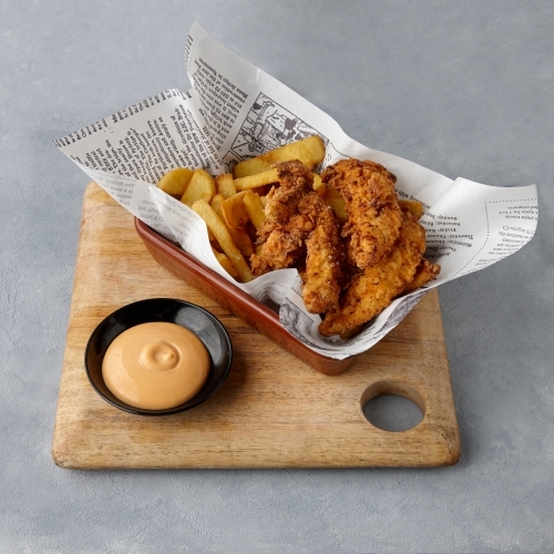 Fried chicken and chips on table - Australian Stock Image