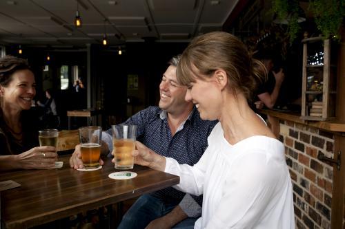 Friends sharing a drink at local craft beer pub - Australian Stock Image