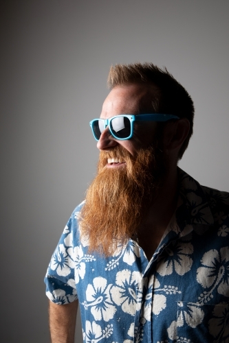 Funky man in a blue floral shirt posing for photographs - Australian Stock Image