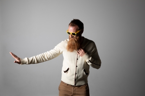 Funky man posing for photographs, wearing a beige shirt - Australian Stock Image