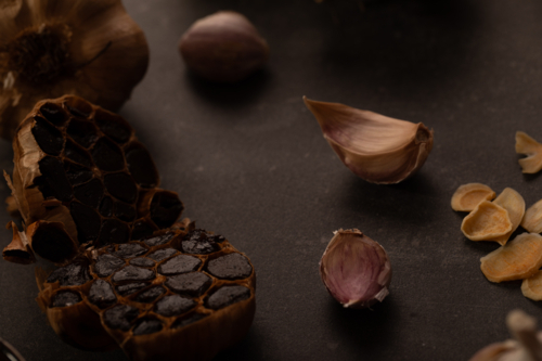 Garlic bulb cut in half to show smoked cloves - Australian Stock Image