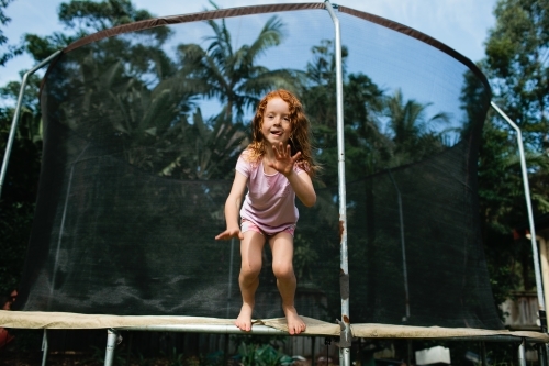 Girl about to jump off a trampoline - Australian Stock Image
