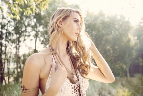 Girl backlit by the sun in a bohemian outfit - Australian Stock Image