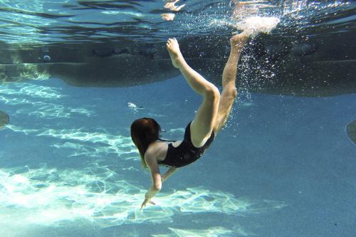 Girl diving underwater in a pool