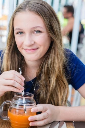 girl drinking juice at cafe - Australian Stock Image