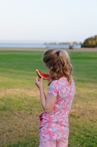 Girl eating watermelon in a park - Australian Stock Image