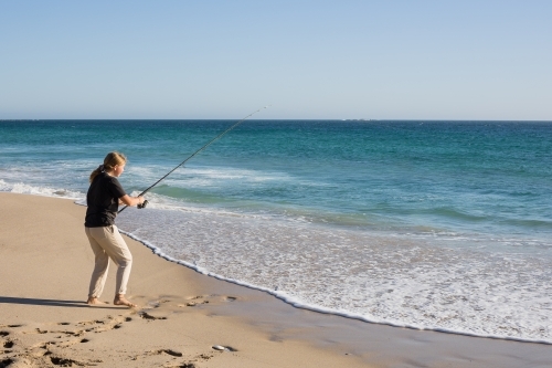 Girl fishing on remote australian beach - Australian Stock Image