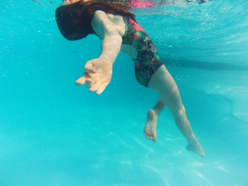 Girl floating undewater in a pool
