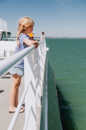 Girl gazing out to the ocean as she crosses on ferry