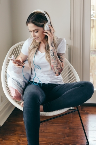 Girl listening to music on her smartphone at home