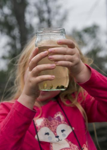 Girl Looking into Glass Jar - Australian Stock Image