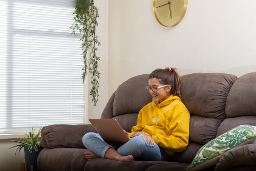 Girl on sofa with laptop computer