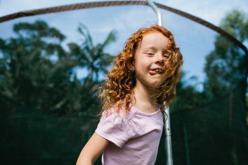 Girl ready to jump from the edge of a trampoline - Australian Stock Image
