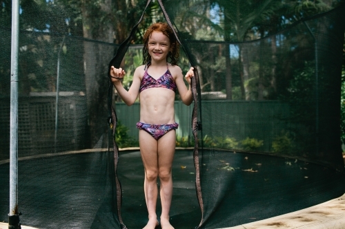 Girl standing on a trampoline in a bikini