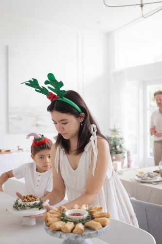 Girl wearing antler headband setting up table - Australian Stock Image