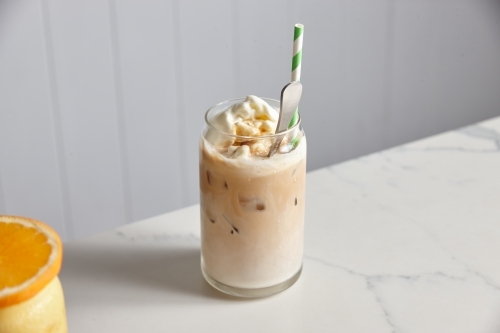 Glass of iced coffee with ice cream, with a glass of orange juice on the side - Australian Stock Image