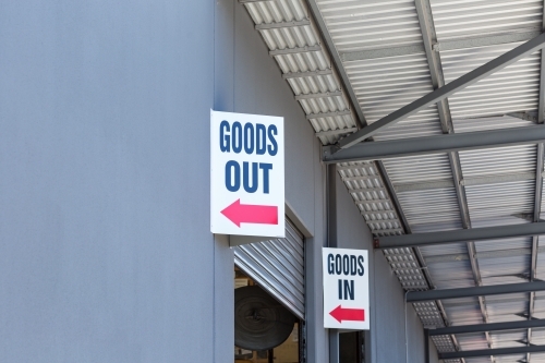 Goods shed with signs for deliveries in and out - Australian Stock Image