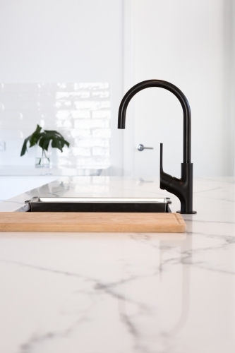 Gooseneck black tapware in a stunning white kitchen - Australian Stock Image