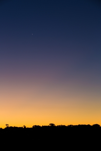 Graduated colour on twilight night sky, with silhouette skyline - Australian Stock Image