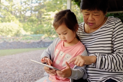 Grandmother and granddaughter using tablet - Australian Stock Image