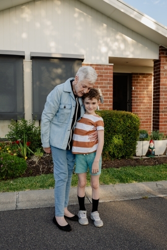 Grandmother "Ma" hugging her grandson in front of her retirement home - Australian Stock Image