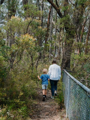 Grandmother spending time with grandson in nature walking along track - Australian Stock Image