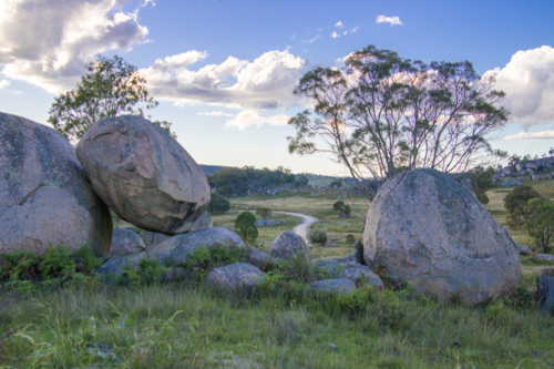 Granite rocks, a winding country road and a cloudy sky - Australian Stock Image