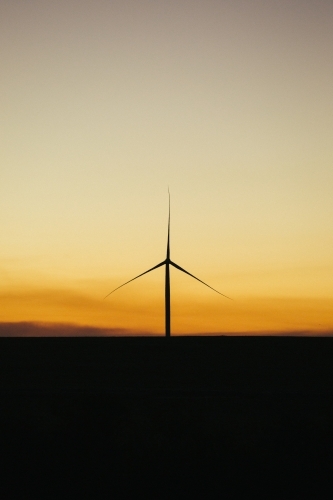 Green energy wind turbine silhouette in the countryside at dusk - Australian Stock Image